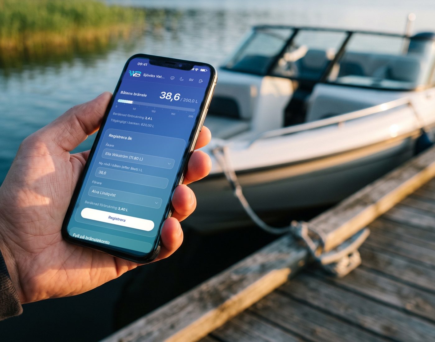A hand holding a phone with Waterski Boatsystem open, on a jetty next to the club boat